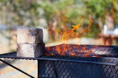 Fire in a rusty vintage grill outdoor on the beach of the sea.