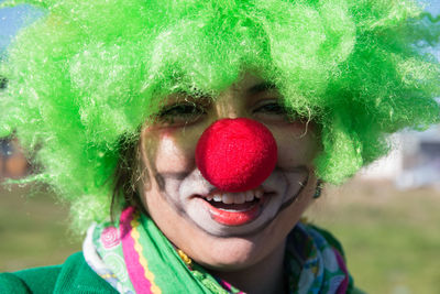 Close-up portrait of smiling woman in clown costume