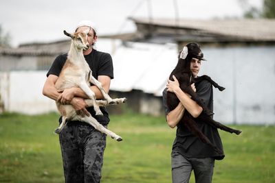 Local agriculture, farmer's day 12 october. a man with a goat in his arms, do-it-yourself natural.