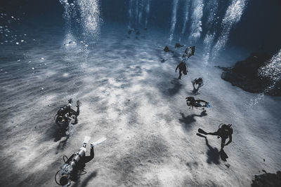 High angle view of divers diving under sea