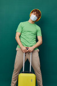 Midsection of man holding bag against blue background