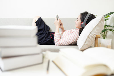 High angle view of woman sitting on bed at home