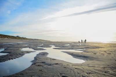 People at beach against sky