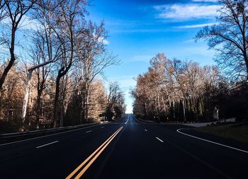 Road amidst trees against sky