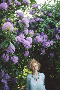 Portrait of woman against purple flowering plants