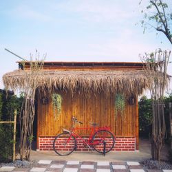 Bicycle by house against sky