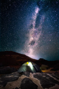 View of the milky way passing over a small tent in the desert