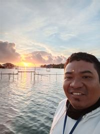 Portrait of man smiling against sky during sunset