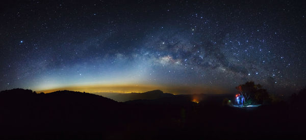 Scenic view of silhouette mountains against star field