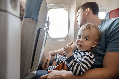 Man with charming infant in plane