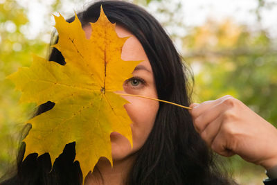 Close-up of woman holding maple leaves