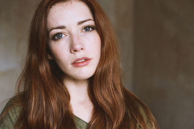 Natural light indoor portrait of young woman with red hair