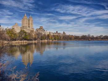 View of temple by lake against sky