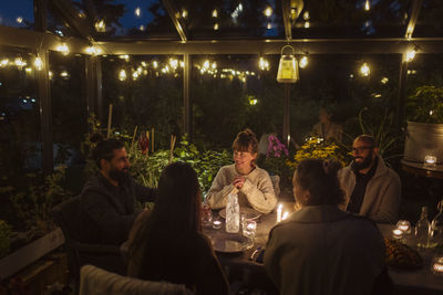 Friends having meal in greenhouse