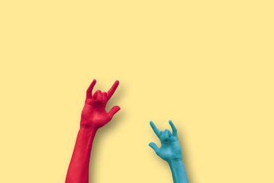 Close-up of hands against colored background