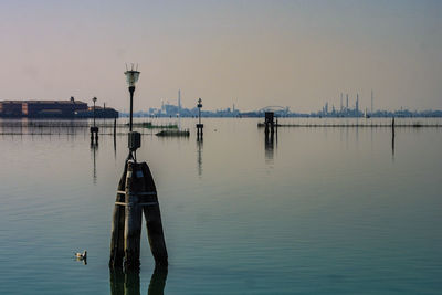 Reflection of man in water against clear sky