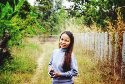 Portrait of smiling young woman in forest