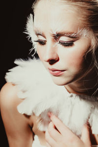 Close-up portrait of beautiful woman against black background