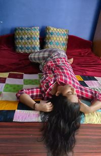 High angle view of woman relaxing on bed at home