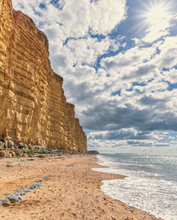  imposing and eroded sandstone cliffs exposing geological layers. west bay dorset jurassic coast. uk