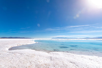 Scenic view of beach against blue sky