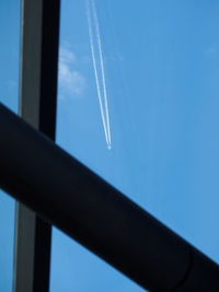 Low angle view of vapor trail against clear blue sky