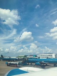 Airplane on airport runway against sky