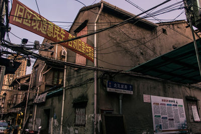 Low angle view of road sign against sky in city