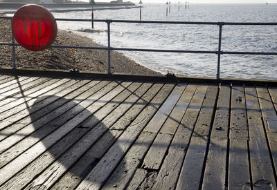 Shadow of railing by sea