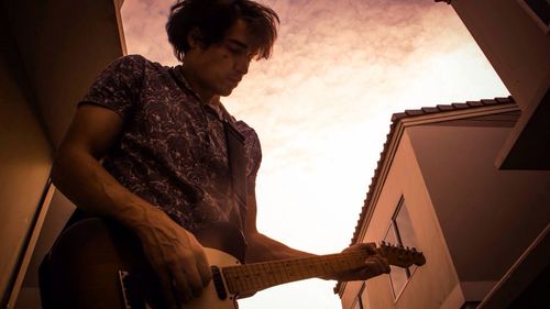 Low angle view of woman standing against sky