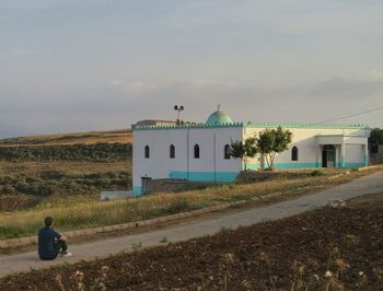 Man in front of built structure against sky