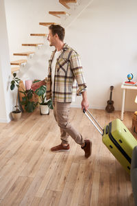 Portrait of young man standing on hardwood floor