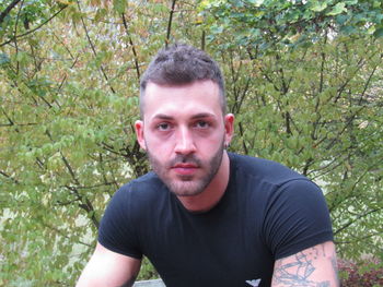 Portrait of young man against trees