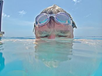 Close-up of man swimming in sea against sky