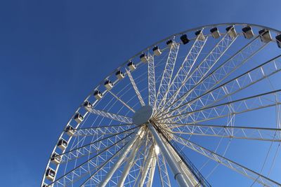 Low angle view of ferris wheel against blue sky