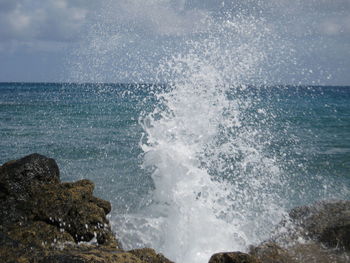 Close-up of waves splashing in sea against sky