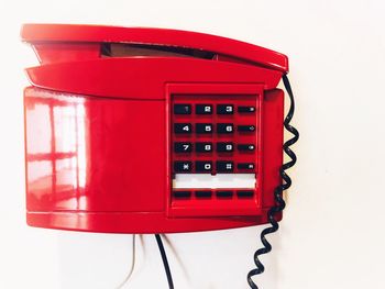 Close-up of red telephone booth against white background