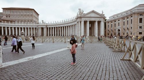 Tourists in front of building against sky