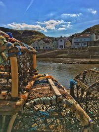 Scenic view of river by houses against sky