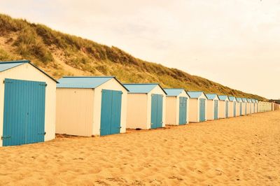 Beach huts by sea against sky