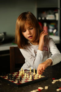 Children playing chess at home kitchen