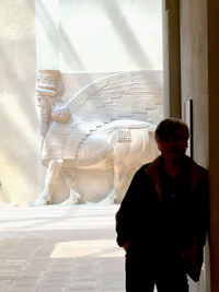 The silhouette of a man in front of an egyptian sculpture.
