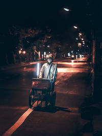 Portrait of man on illuminated street at night