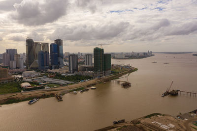 Aerial view of buildings in city against cloudy sky