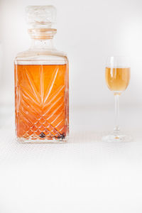 Close-up of glass bottle on table against white background