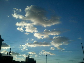 Low angle view of power lines against blue sky