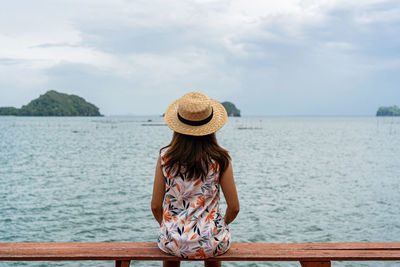 Rear view of woman in sea against sky