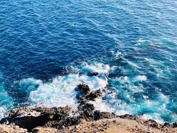 High angle view of waves breaking on rocks