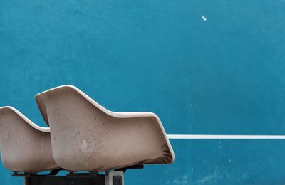 Empty plastic chairs against wall