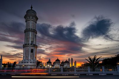 Illuminated buildings against sky at sunset